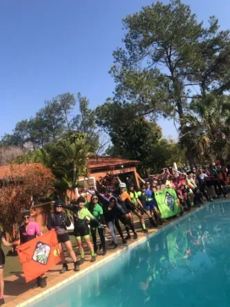 Ciclistas posando em frente à uma piscina
